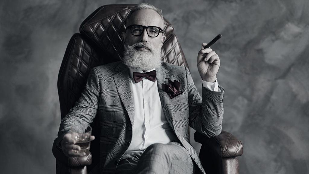 Man seated in a leather armchair with the pose of confidence and assurance that he knows the operations of his business. Ready for a Humming Session