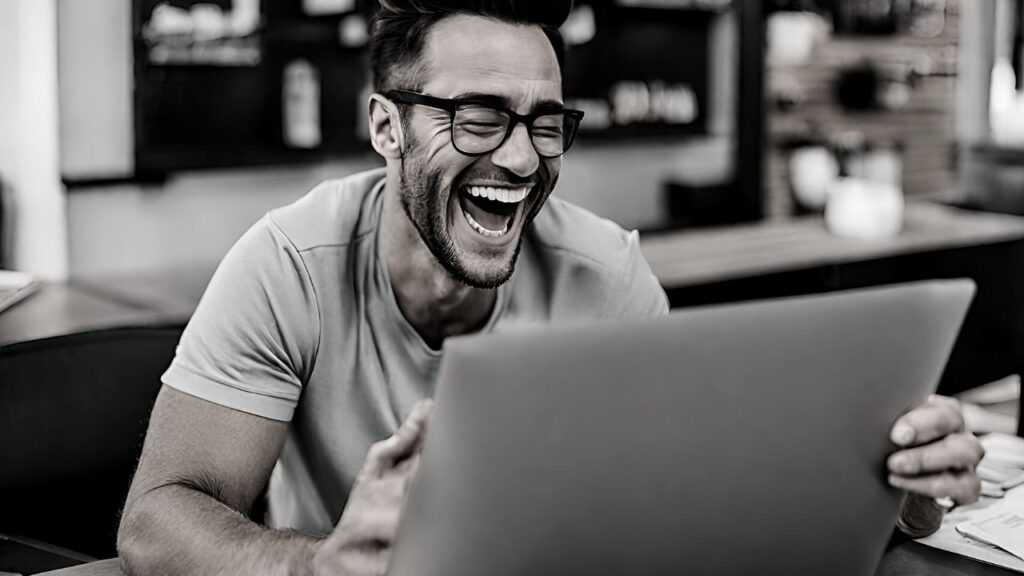 A man laughing as he engages in a Humming Session on his laptop. 3 Unmistakable Signs of an Unhealthy Business Ego (And How to Address Them)